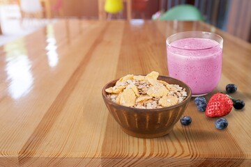 Glass of tasty berry smoothie with oatmeal on kitchen table