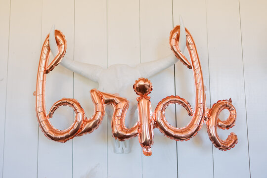 Bride Balloon Letters Against A White Wall And White Bull Wall Sculpture