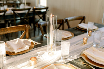 Hurricane pillar candle on table at a reception.