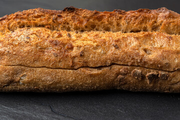 Sourdough bread with crispy crust on wooden shelf. Bakery goods