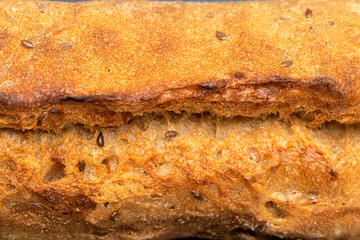 Sourdough bread with crispy crust on wooden shelf. Bakery goods