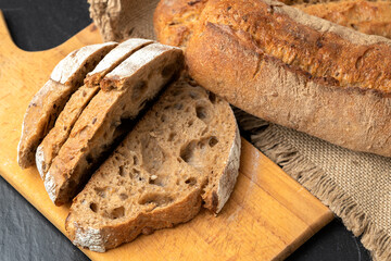 Sourdough bread with crispy crust on wooden shelf. Bakery goods