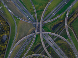 Intersection highway junction crossroad overview top down aerial. Infrastructure road and motor way driving busy street roundabout. Asphalt transportation from above.