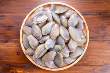 Striped Clam or Clam bivalve molluscs  on wooden background for seafood dish. © KT Studio
