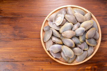 Striped Clam or Clam bivalve molluscs  on wooden background for seafood dish. © KT Studio
