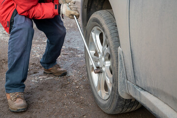 A man is changing the wheels on a car. Safety, car maintenance.