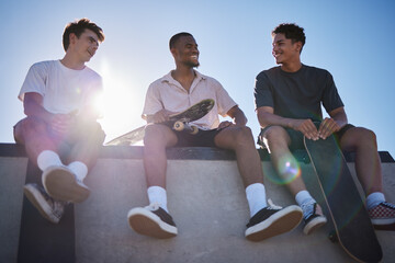 Diversity, friends and men with skateboard together talking on wall in city. Happy conversation,...