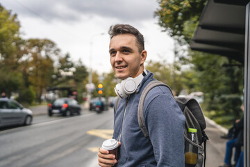 one young adult man student or tourist use mobile phone while wait bus