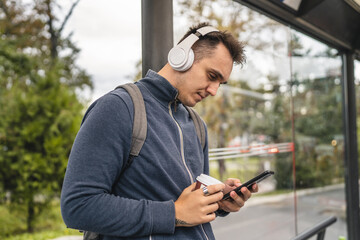 Fototapeta premium One man young adult male stand at public transport bus station waiting