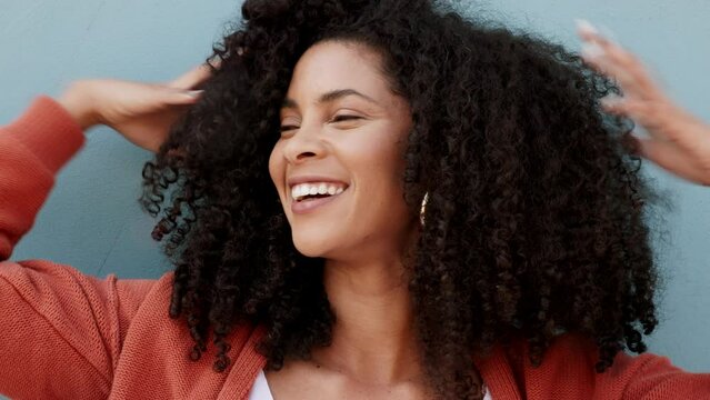Natural, curly and black woman playing with volume after using curling haircare product. Attractive African american girl with healthy and strong curl definition in hair for beauty campaign.