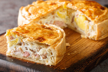 Bacon and egg puff pie closeup on the wooden board on the table closeup. Horizontal