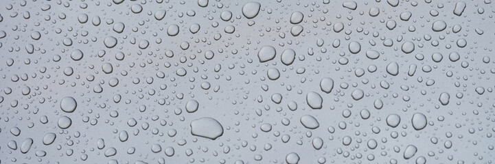 Closeup of raindrops on gray window glass texture background