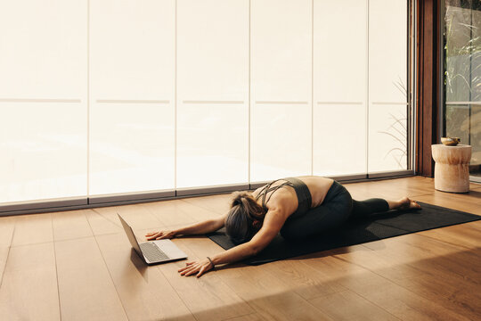 Woman Doing A Balasana Exercise During An Online Yoga Class