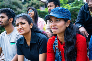 medium shot of Girl got sad while watching sports match at stadium due to missed goal in football -...