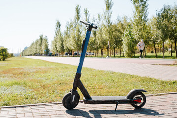 Electric scooter parked in the park on a sunny summer morning © Sergio