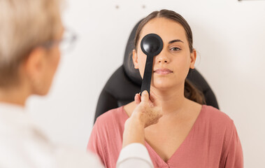 Woman, eye exam and vision test with occluder at optometrist for eyesight, glasses or checkup at...