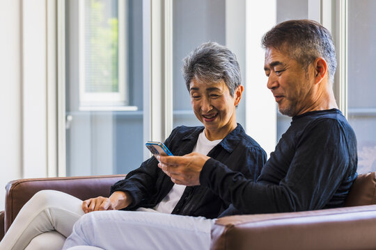 スマートフォンを見る日本人シニア夫婦