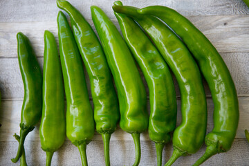 Hot chili pepper background. Green peppercorns on a gray wooden table background. Healthy food concept.