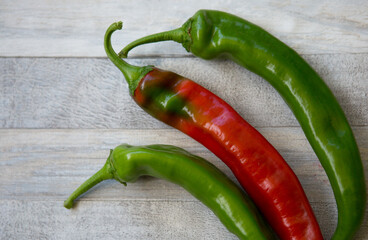 Hot chili pepper background. Red and green peppercorns on a gray wooden table background. Healthy food concept.