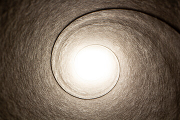 Vue macro de l’intérieur d'un rouleau d'essuie-tout avec une lumière au bout