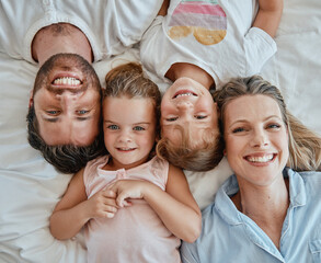 Top view, family and portrait in bedroom home, bonding or having fun. Love, care and happy kids or...
