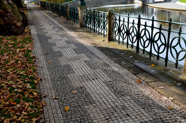 waterfront promenade in the shade under the trees. geometric paving made of small geometric shaped...