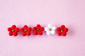 日本の正月イメージ　紅白のちり緬の梅のデザイン(ピンクの和紙の背景）