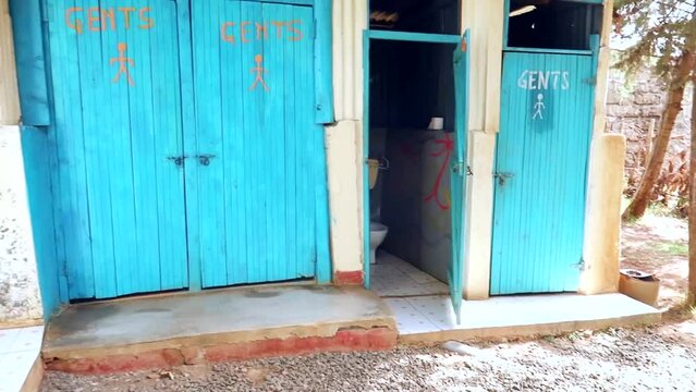 View of tourist bathroom with bright blue doors marked ladies and gents in an area of Kenya, Africa