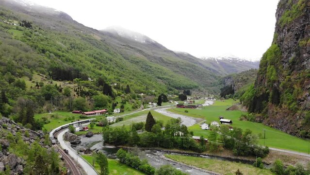 Aerial: Fl&aring;m train going through a valley among green meadows