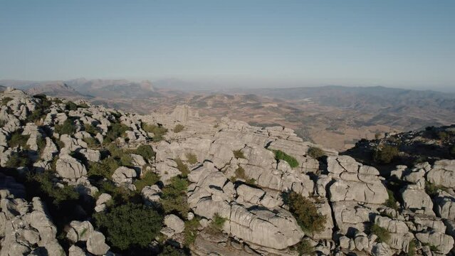 Aerial drone backward moving shot over impressive rocky mountain tops  in Torcal de Antequera, Karstik rocks, Spain at dusk.