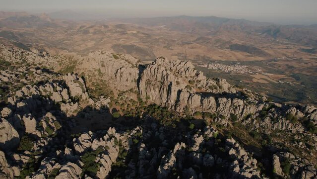 Aerial drone rotating shot over impressive rocky mountain tops  in Torcal de Antequera seen from above. Karstik rocks in Spain during evening time.