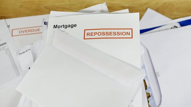 A stack of bills and debts with a mortgage repossession notice letter