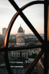 Vertical of New Church on the Gendarmenmarkt Square in Berlin,Germany at sunset behind metallic bars