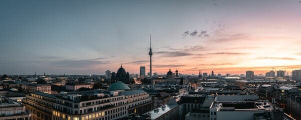 Panoramic shot of TV tower and Berlin downtown under a pink cloudy sky at sunset