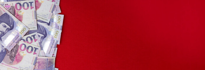 Horizontal banner with Georgian paper money. 100 GEL. One hundred lari on a red textile background....