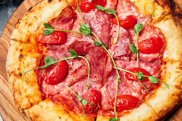 Pizza with salami, tomatoes and mozzarella