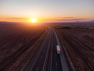 Aerial view of highway road at sunset in autumn. Top view from drone of road