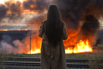 Woman watching the wild fire burning, back view
