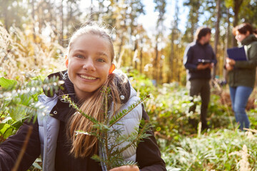 Glückliches Mädchen mit Nadelbaum für Aufforstung im Wald