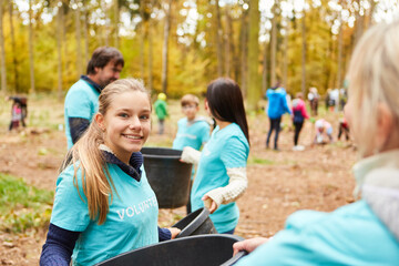 Kinder und freiwillige Helfer sammeln Müll im Wald