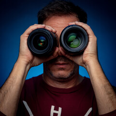 man looking through photographic lenses