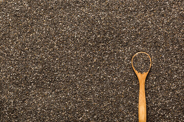 Space for text Texture of chia seeds with wooden spoon, superfood concept. Top view