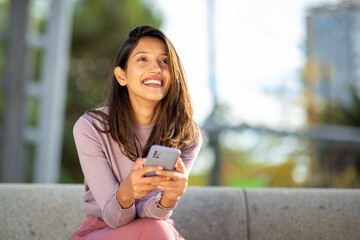 happy young woman holding cellphone in hand