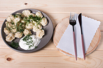 boiled dumplings with dill and sour cream. Homemade dumplings with meat