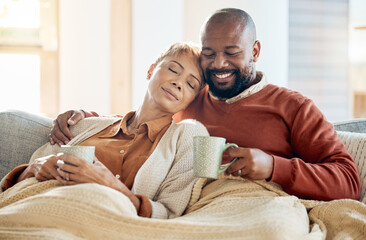 Black couple relax on sofa with coffee, blanket and smile on winter weekend morning in home. Peace,...