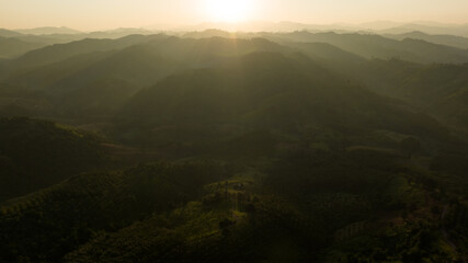 Landscape of mountains layer and forests. The sun rays are shining through the fog. The play of light and shadows. dramatic natural scenery north of thailand. aerial view