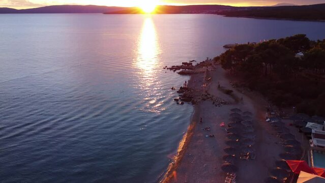 Aerial view of Croatian pebble island beach at sunset on Krk island near Punat