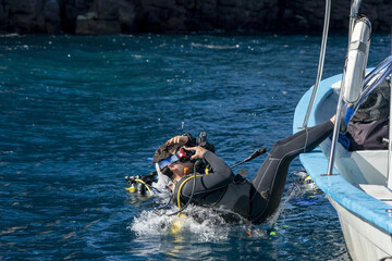 scuba diver entering water from boat