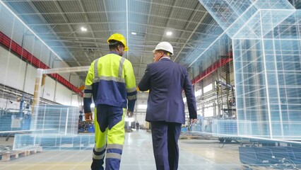 Back view of engineer and businessman walking at manufacturing plant with holographic room scan - Powered by Adobe