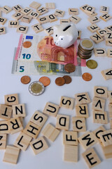 paper euro banknotes, piggy bank, bills on table among euro coins, finance investment economy and management payment tax banking with wood blocks, concept of employee salary, money savings